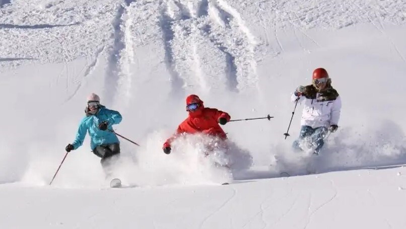 3 friends skiing down a slope at Alta ski resort