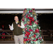 Mayor Mac Caradine addresses the attendees in front of a beautiful Christmas tree.